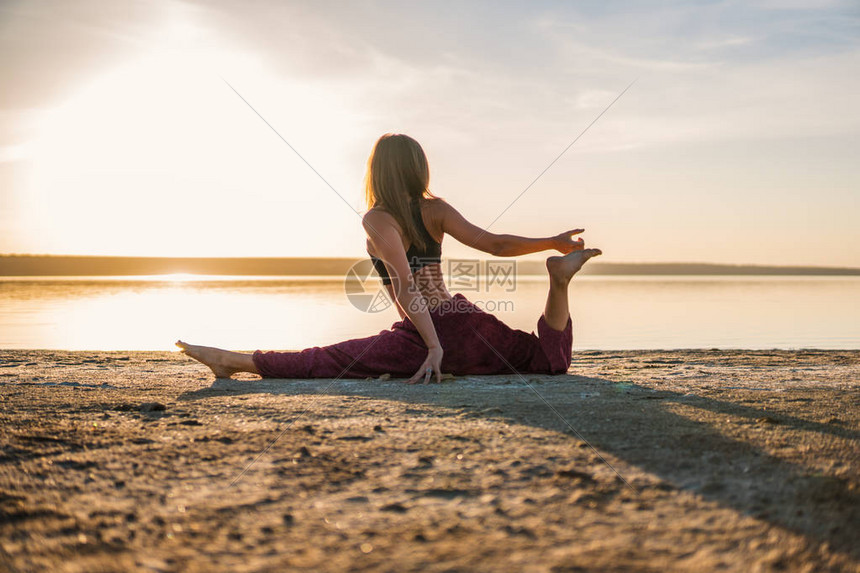 日落时在沙滩上做瑜伽的月光女人早间自然图片