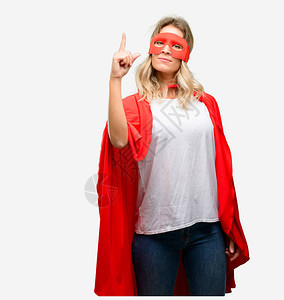 年轻的超级英雄女英雄穿着披风举背景图片
