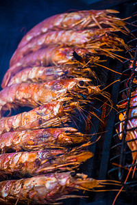 虾肉烧烤热辣的烤虾上开胃大虾在黑图片