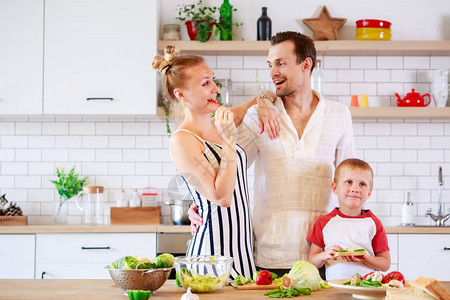 父母和小儿子在家厨房准备食物的照片图片