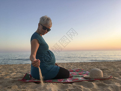 怀孕九个月的女人在海滩上图片