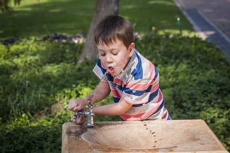 口渴可爱的白人小男孩从街头饮水机喝水孩子从饮水机里喝水口渴库存图片夏季酷暑图片