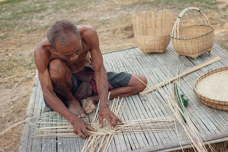 亚洲老人在乡下制作竹柳条图片