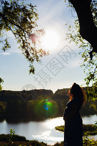 一位站在湖岸边的孕妇的特征简介图片