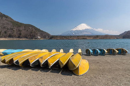 河口湖和富士山背景海岸上的船只图片