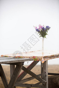 雾背景下乡村木桌上的野花束图片