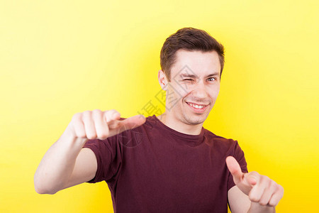酷的自信的家伙用他的手指在摄影棚照片中的黄色图片
