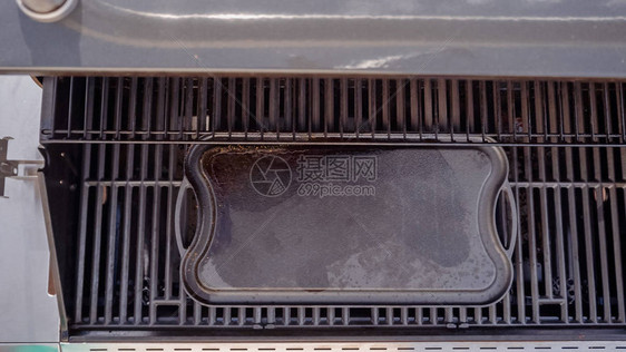 户外燃气烤架上的空铸铁烤盘图片