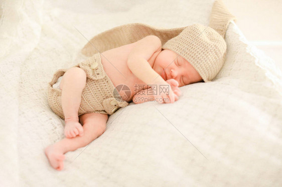 刚出生的小婴儿睡觉和穿着钩针编织的衣服图片