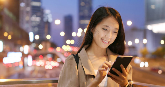 晚上在城市使用手机的女商人图片