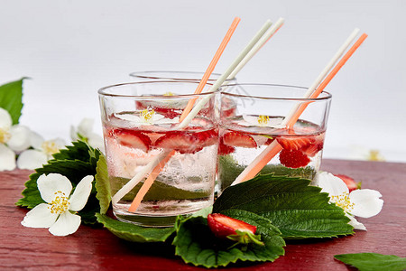 茉莉花草莓排毒水夏季冰镇饮料或茶柠檬水配浆果新鲜草莓玻璃杯中的图片