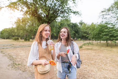 有吸引力的女孩用棒糖和柠檬水vv微笑的肖像在公园散步快乐时尚的女朋友图片