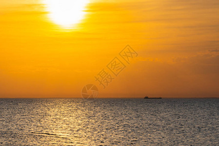 一艘货船在日出时在地平线上航行图片