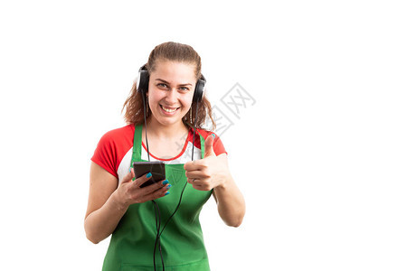 年轻零售女销售员聆听音乐和大拇指举起手势图片