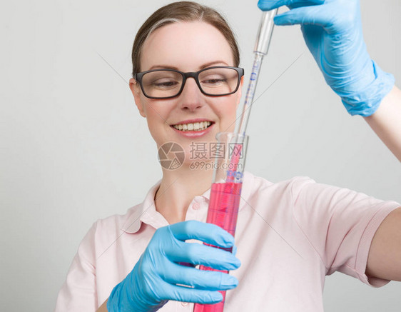 女科学家用试管测量实验室中的润滑剂图片