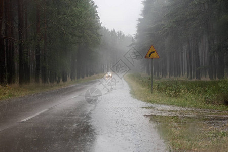 雨中汽车的行驶道路森林里有路标的荒凉道背景图片