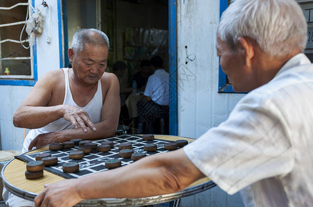 两名男子在邓港市街头玩棋图片