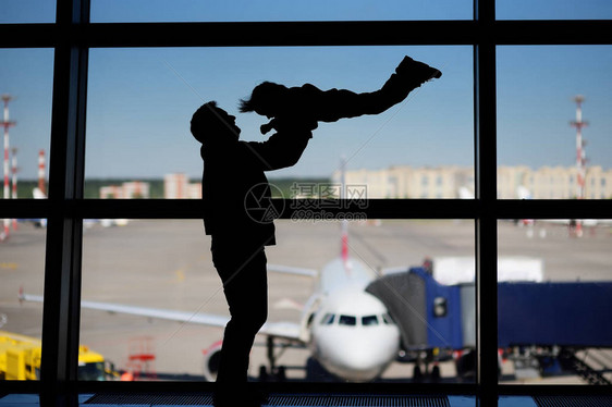 男人带着小男孩在国际机场玩得开心父亲带着他可爱的小儿子等待登机家庭旅图片