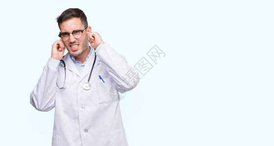 英俊的年轻医生男子用手指遮住耳朵图片