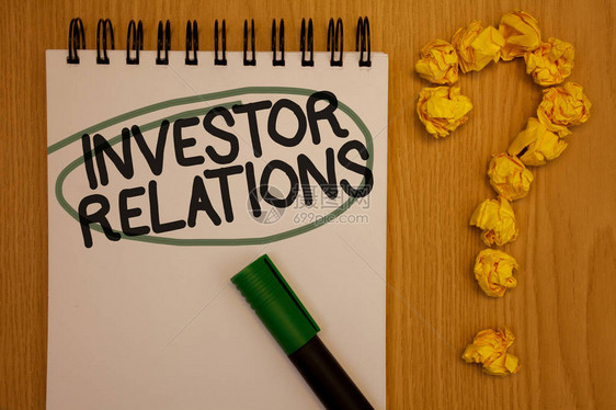 显示投资者关系的书面说明商业照片展示金融投资关系谈判股东记事本圆黑字绿笔木质桌球图片