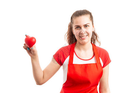 年轻女超市雇员或店主持有红色玩具心脏图片
