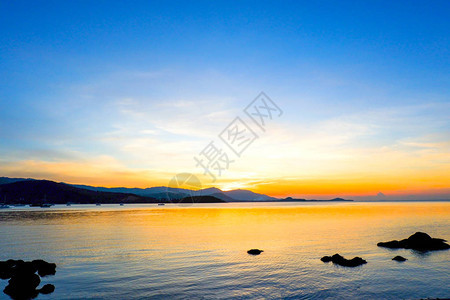 夏季时海上和热带海滩的美丽日落日落黎明和日出的自然背景与明亮的戏剧风景天空在天际线上图片