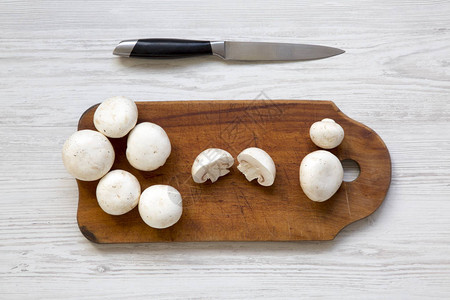 木板上的香格里昂蘑菇用刀刺穿白木背图片
