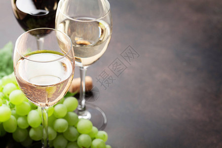 石桌上的葡萄和葡萄酒杯图片