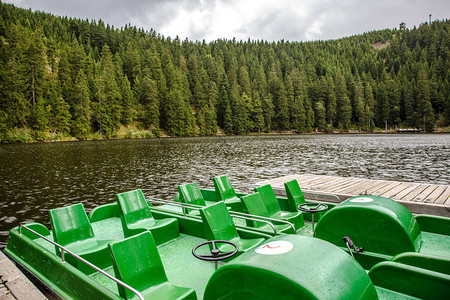 在阴云多的山湖上空绿色座位分布宽广的旅游者或渔船图片