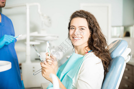 诊所牙科医拿着牙刷和牙镜的微笑的年图片