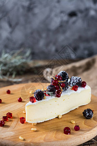 法式奶酪布里干酪加蜂蜜果酱和松子的camambert在木制奶酪板上浆果酱和蜂蜜图片