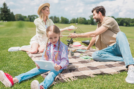 小可爱小孩在野餐时与父母一起休息时图片