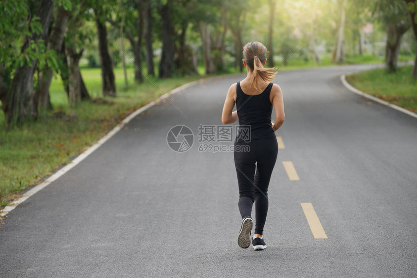 年轻健身女早上在路上奔跑太阳光耀斑选择聚焦点图片