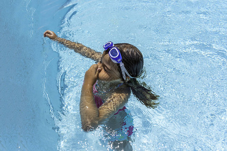 小女孩在游泳池里戴游泳眼镜图片
