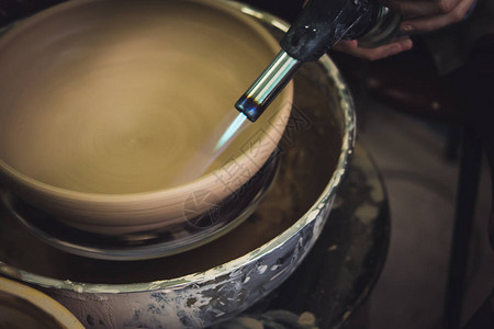 陶工烧了一个未加工的粘土产品特写黑暗的瓦罐大师车间里的雕塑家用粘土制作了一个壶陶工近距离工作手工制作的工艺图片