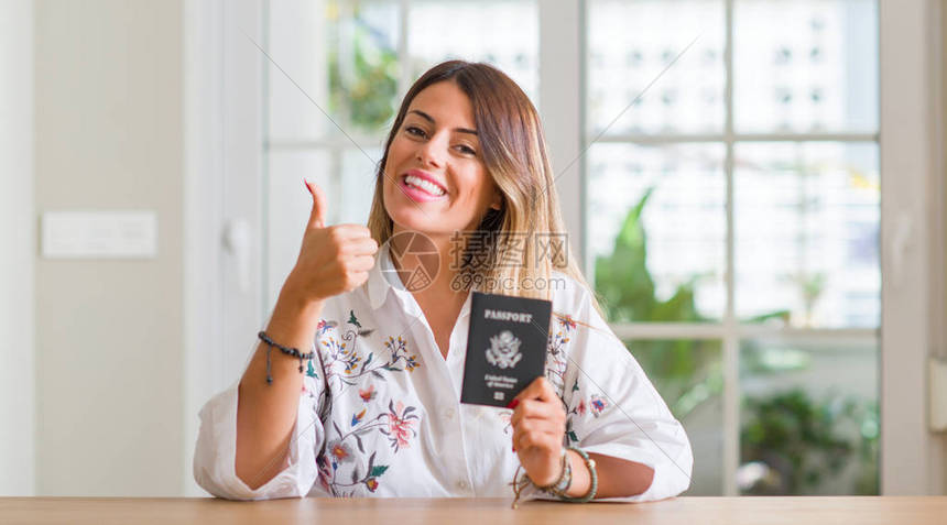 在家拿着美国护照的年轻女人开心地笑着做好手势