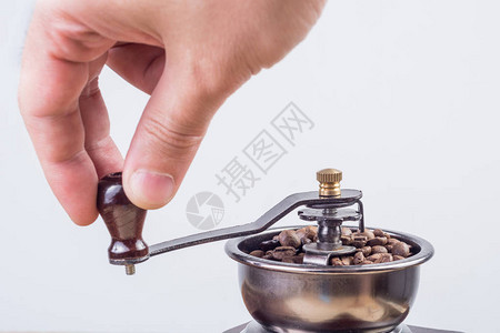 雄手在老旧的倒古咖啡面包机里磨咖啡豆中磨制咖啡豆图片