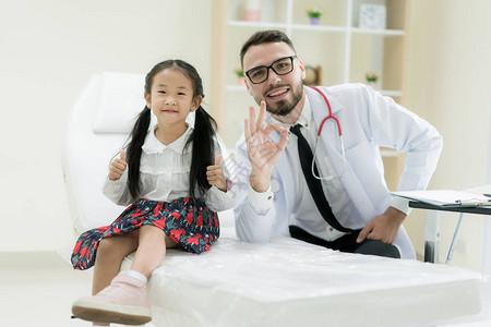 医生和可爱的小女孩在医院露出好兆头医学和医疗保健概图片