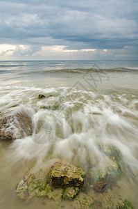 美丽的白色和柔软的波浪从岩石上流过图片