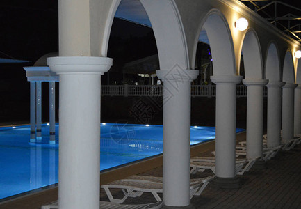 深夜的景象豪华泳池与柱形和拱门图片