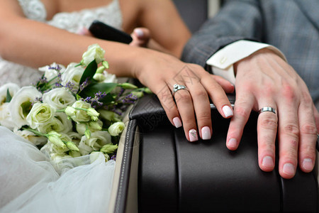 新婚夫妇手握结婚戒指和花束紧图片