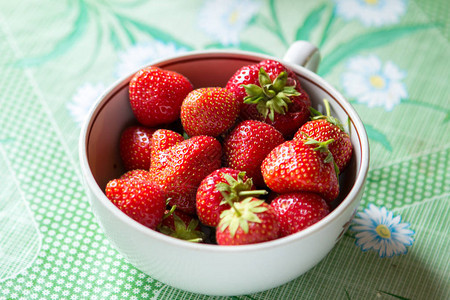 熟的草莓贝果绿叶在绿色桌图片