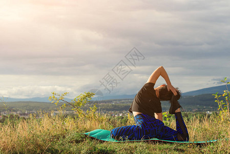 户外瑜伽锻炼年轻女子坐在岩石上的瑜伽姿势自由平静和放松图片