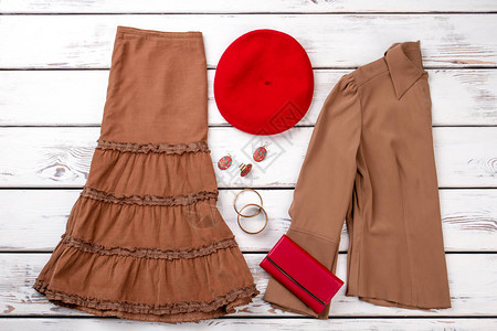 棕色衣服红色钱包和贝雷帽白背景图片