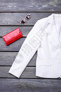 白色夹克红色钱包和太阳镜黑色背景图片