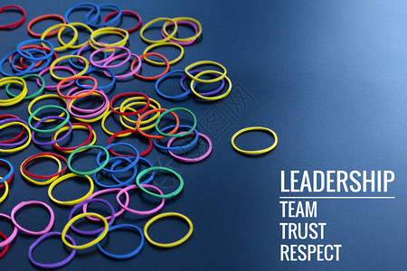 领导经营理念黄色橡皮筋以黑色背景上的领导团队信任和尊重一词图片
