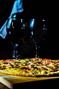 红葡萄酒和美味的比萨饼还有培根火腿蘑菇和薄地壳上的马扎里拉图片