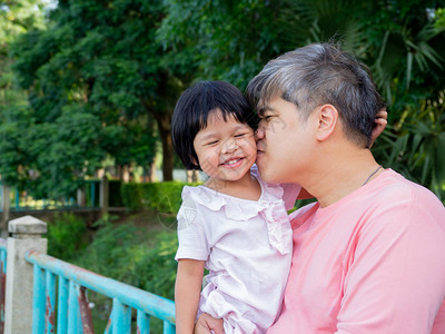女儿在父亲的怀抱中用爱亲吻对方亚洲图片