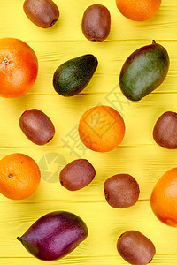 黄色木质背景上的各种新鲜有机水果图片