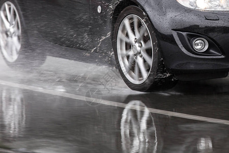 运动车在雨路上驾驶车轮紧靠方向盘图片